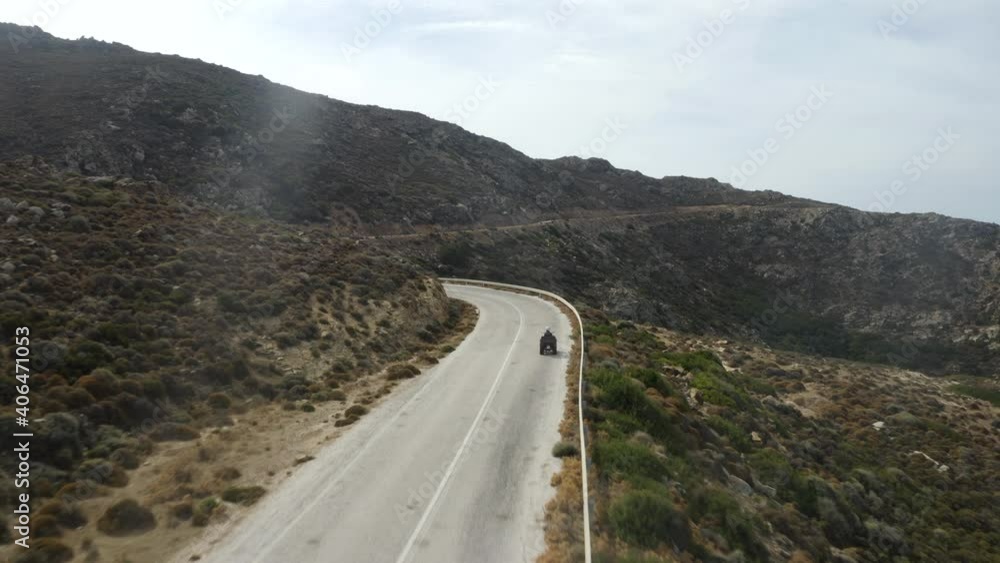 Fast flying drone following couple on ATV, quad bike in the mountains of Ios, Greece Fast flying drone following couple on ATV, quad bike in the mountains of Ios, Greece
