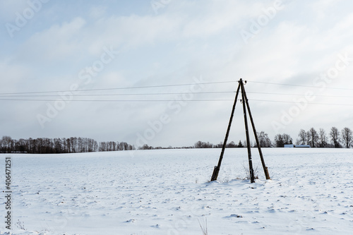 snowy white field on which stands an electric pole with three stages