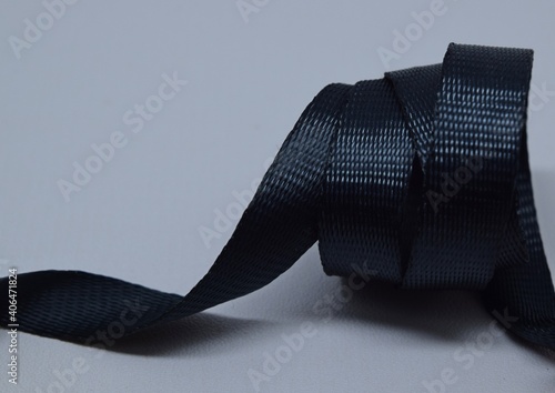 Black glossy nylon twill webbing on white background.
