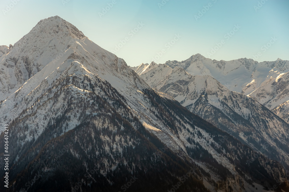 Obraz premium melting snow reveals texture of mountin with trees begining to show after winter