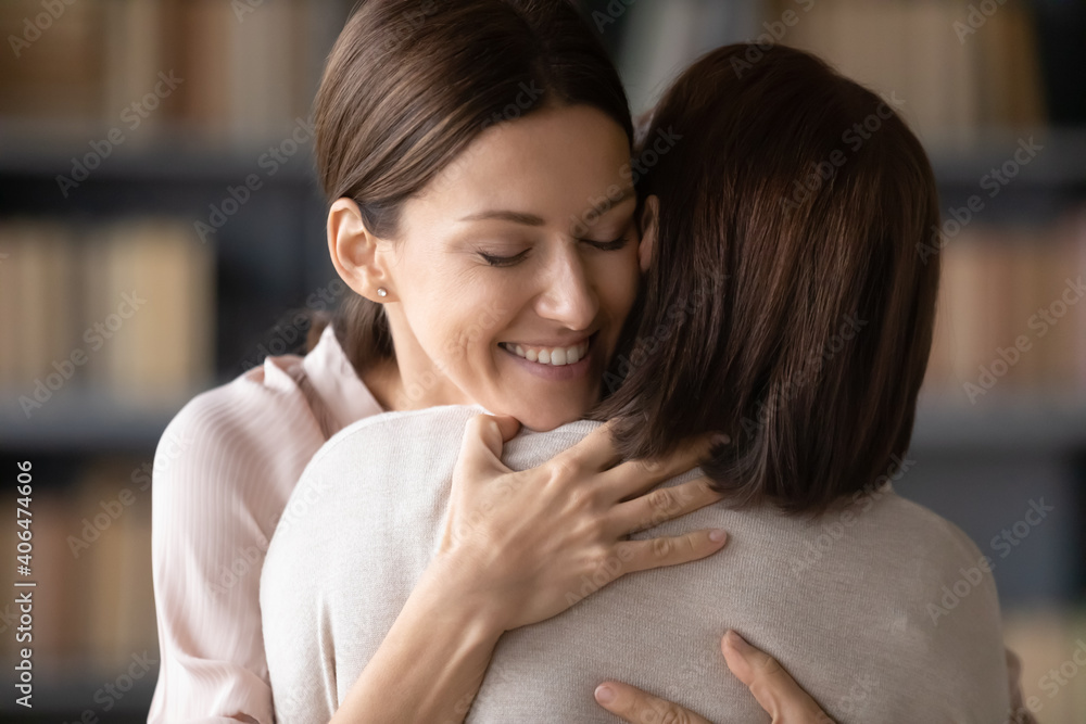 Close up loving smiling attractive young woman hugging mature mother, family enjoying tender moment, happy positive grownup daughter and middle aged mum cuddling, expressing support and care Close up loving smiling attractive young woman hugging mature mother, family enjoying tender moment, happy positive grownup daughter and middle aged mum cuddling, expressing support and care