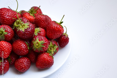 Fototapeta Naklejka Na Ścianę i Meble -  Strawberries on white plate. Freshly picked strawberry. Organic berries on white background. Village garden harvest.