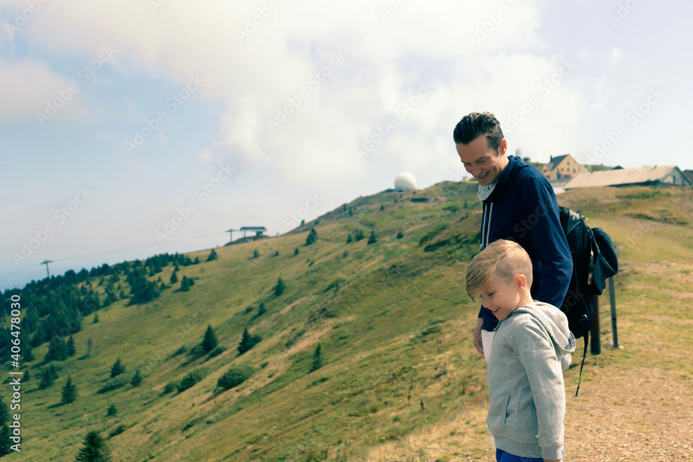 Happy father and son spending day outdoors in the mountains.