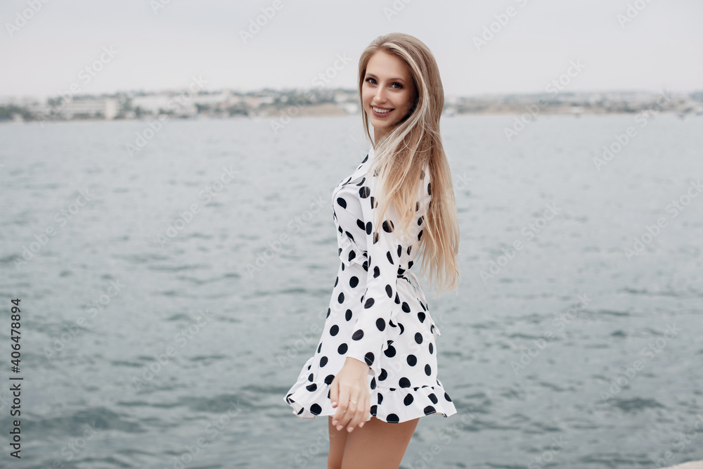 Young happy woman in sunny dress outdoors