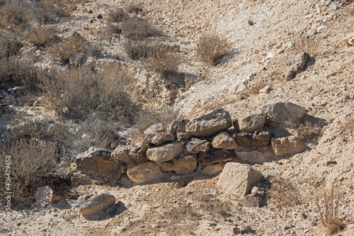 closeup detail of the ruins of a small crude possibly prehistoric neolithic stone age dam located in a chalky little gully at the west end of the makhtesh ramon crater in israel