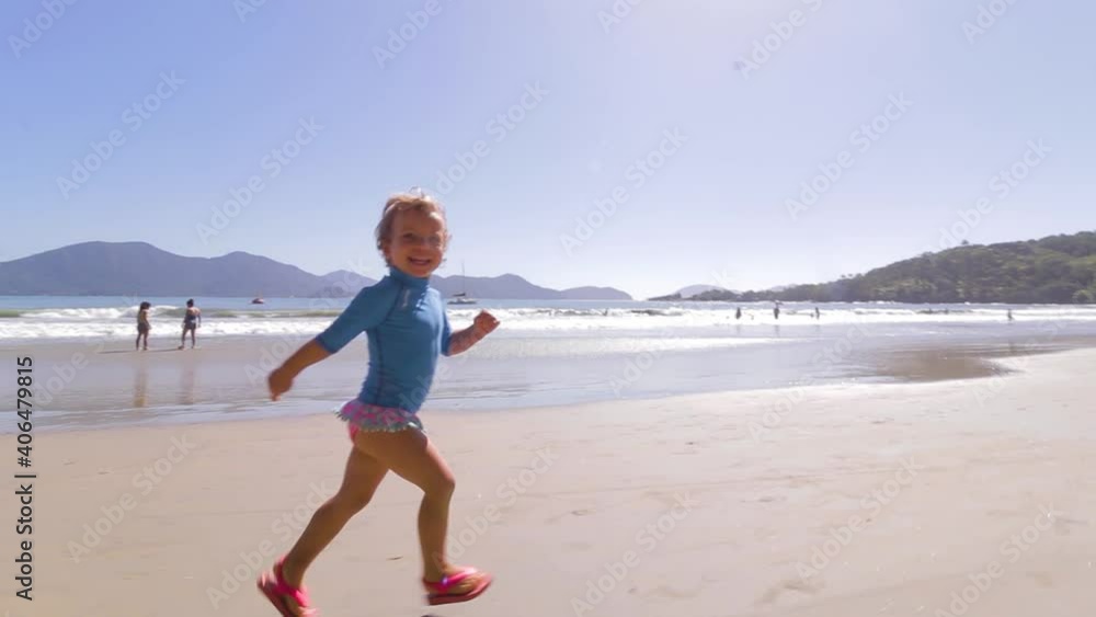 camera orbiting around young cute girl running freely on the beach with mountains background and calm sea and clear sand camera orbiting around young cute girl running freely on the beach with mountains background and calm sea and clear sand