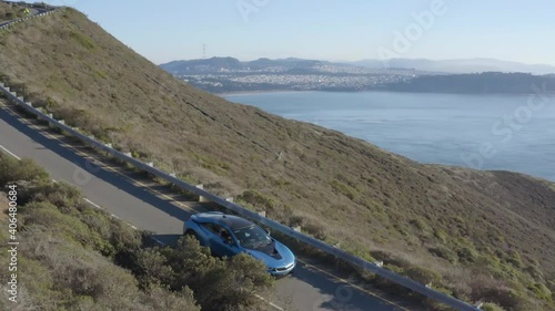 Blue BMW driving on coastal road in Marin Headlands, California. Aerial view photo