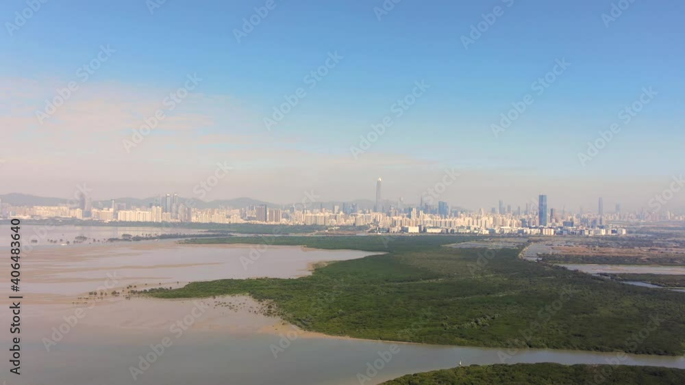 Hong Kong and Shenzhen border line over Hong Kong rural houses with Shenhzen skyline in the horizon, Aerial view. Hong Kong and Shenzhen border line over Hong Kong rural houses with Shenhzen skyline in the horizon, Aerial view.