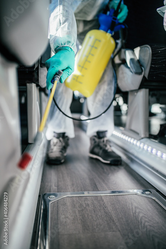 Professional chemical cleaning bus seats. Bus disinfection. Exterminator in workwear.