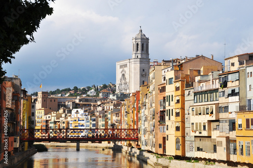 City panorama with a river  a bridge and houses of different colors.