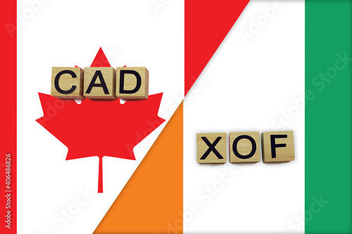 Canada and Cote d'Ivoire currencies codes on national flags background © andreyakaan147