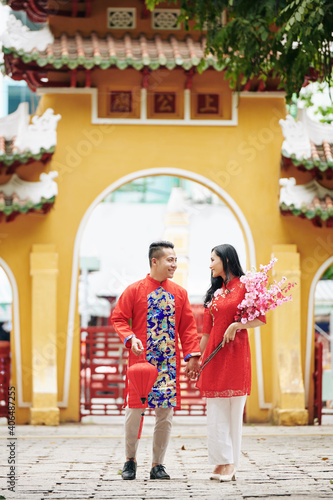 Young Vietnamese couple holding hands when vising temple on Lunar New Year © DragonImages