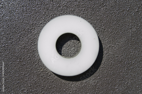 white methacrylate circle with empty center, isolated on black rough background photo