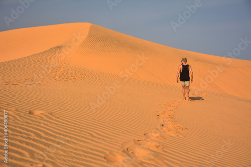 young man in red sand dunes in Mui Ne  Vietnam