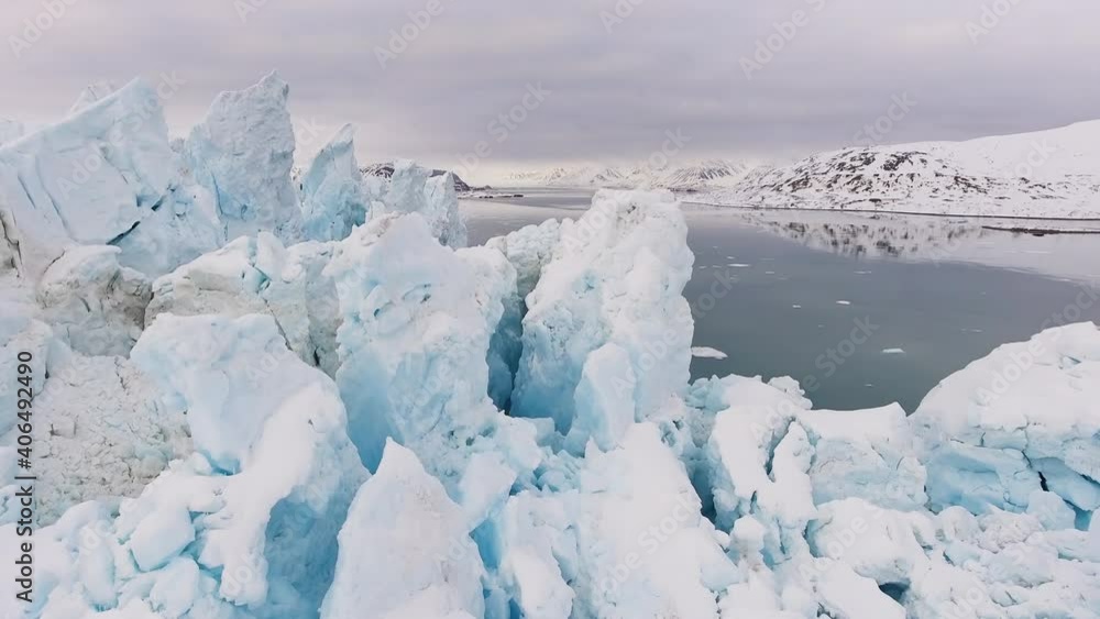 Large glacier on sea in frozen hilly landscape, close up drone shot Large glacier on sea in frozen hilly landscape, close up drone shot