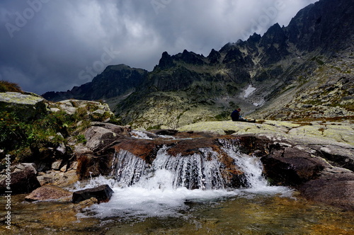 Small waterfall in a mountainous rocky surroundings on a cloudy day in the High Tatras mountains in Slovakia