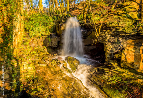 A long exposure view of water cascading over a top-level waterfall at Lumsdale on Bentley Brook, Derbyshire, UK