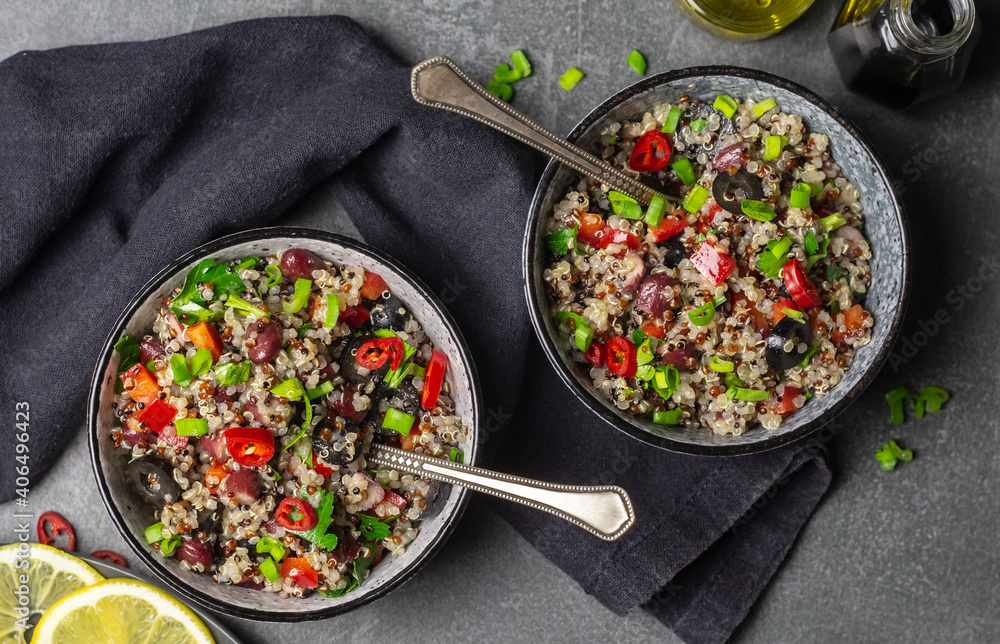 Two bowls of quinoa, paprika, beans and olives Two bowls of quinoa, paprika, beans and olives