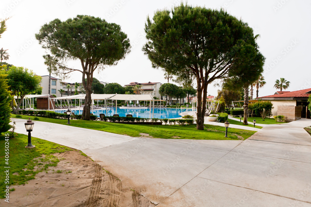 Naklejka premium Hotel pool surrounded by trees by the sea