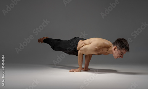 Male yoga keeps horizontal balanc on hands