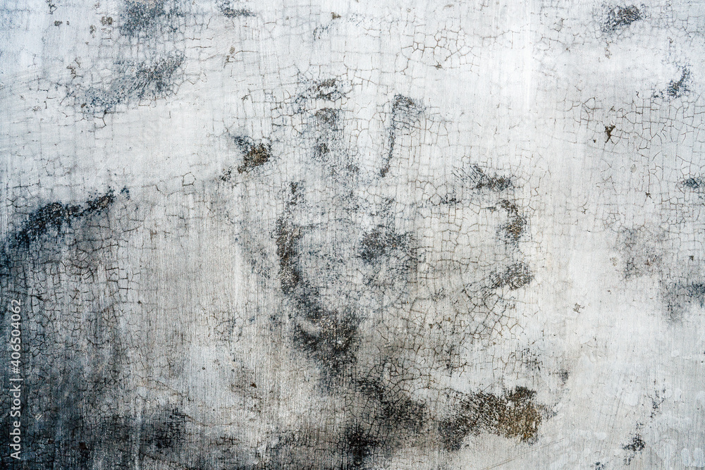 Obraz premium Peeling paint on a concrete wall with brownish black patches emerging from underneath. Close up.