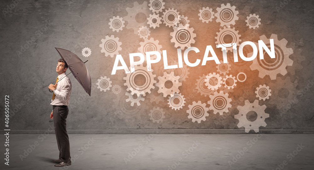 Businessman defending with umbrella from APPLICATION inscription, technology concept Businessman defending with umbrella from APPLICATION inscription, technology concept