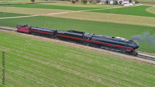 Aerial View of a Restored Antique Steam Locomotive Pulling a Caboose on a Sunny Fall Day