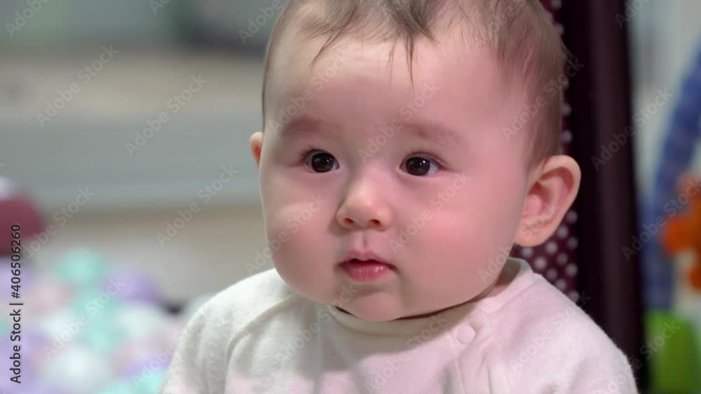 Cute Baby Girl Sitting And Curiously Looking Around Inside A House. - close up Cute Baby Girl Sitting And Curiously Looking Around Inside A House. - close up