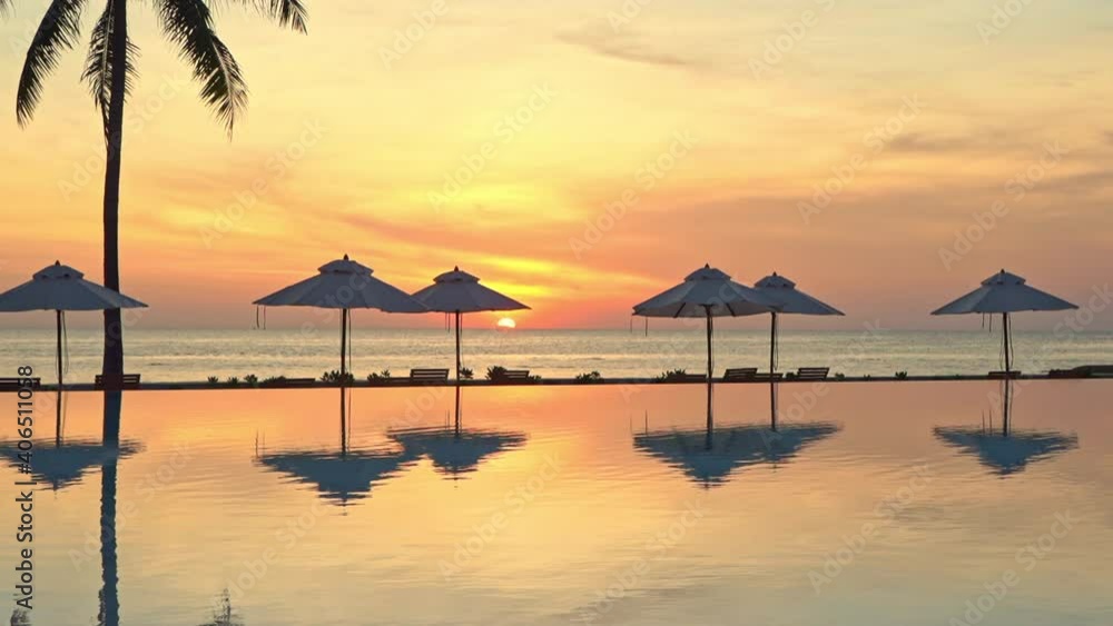 Orange Tropical Sunset Above Sea and Pool of Luxury Resor With Tree and Parasols Silhouettes and Mirror Reflection on Water, Static Orange Tropical Sunset Above Sea and Pool of Luxury Resor With Tree and Parasols Silhouettes and Mirror Reflection on Water, Static