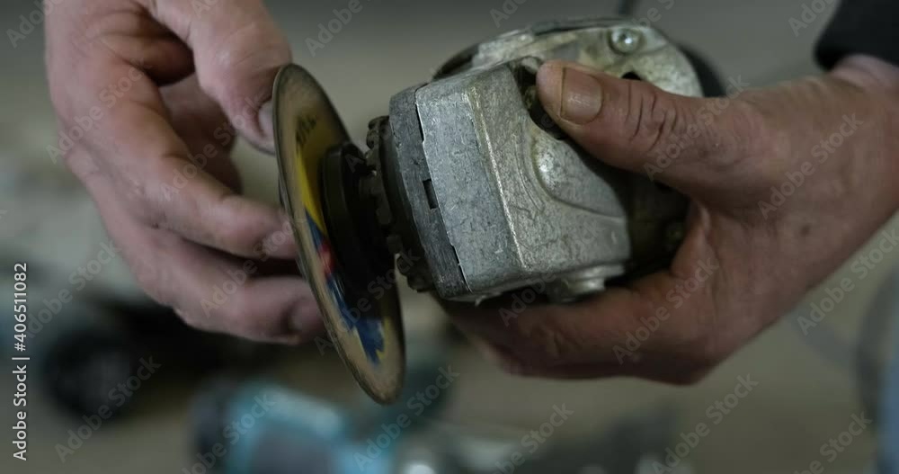 Close Up Of A Worker's Hands Removing Grinding Disc From An Angle Grinder For Changing. static shot, slow motion Close Up Of A Worker's Hands Removing Grinding Disc From An Angle Grinder For Changing. static shot, slow motion