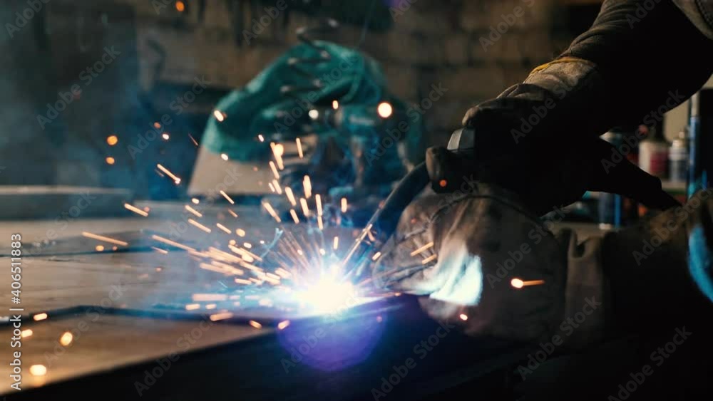 Welder on the table welds a set of metal parts. Welder working. Working with metal Welder on the table welds a set of metal parts. Welder working. Working with metal