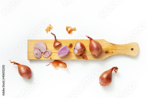Fotografia Whole and cut shallot over white background cutting board