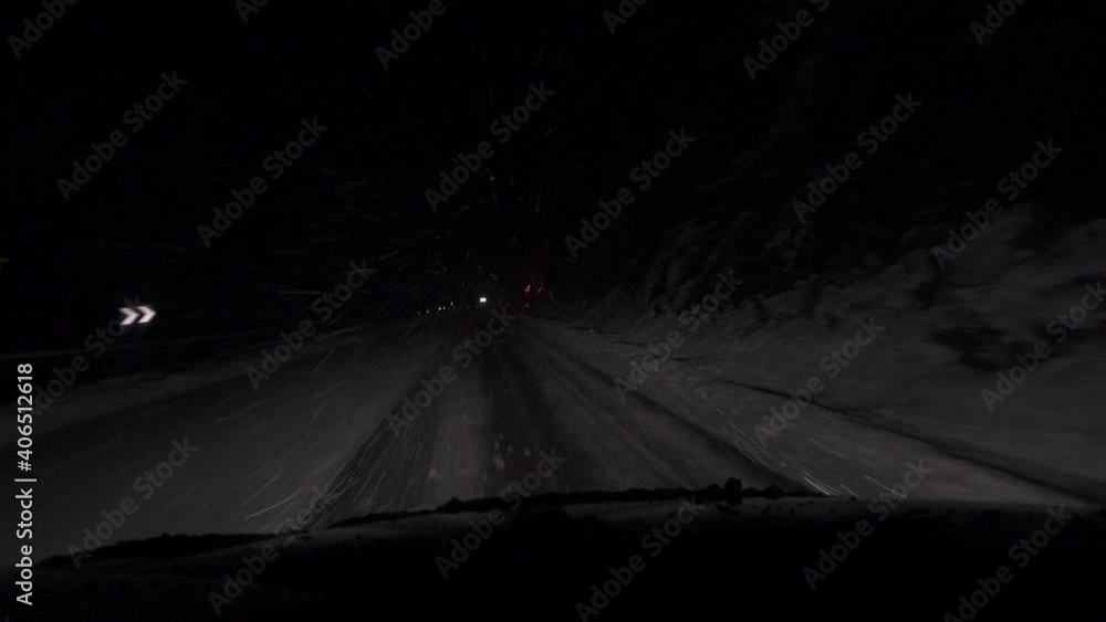 Driving on a snowy road at night during the winter season behind a snowplow. - POV, Point of view Driving on a snowy road at night during the winter season behind a snowplow. - POV, Point of view