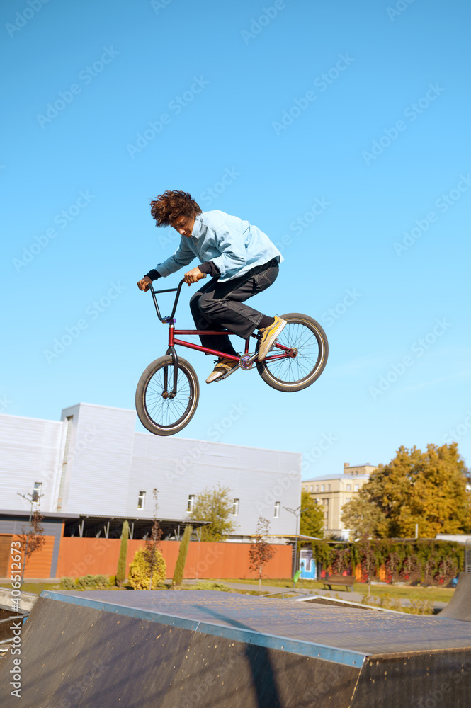 Obraz premium Male bmx biker doing trick on ramp in skatepark
