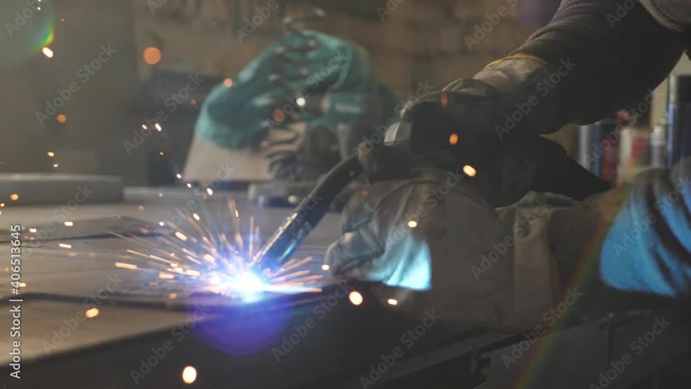 Welder on the table welds a set of metal parts. Welder working. Working with metal Welder on the table welds a set of metal parts. Welder working. Working with metal