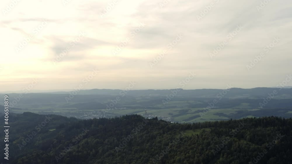 Rising aerial of green hills and distant rural town in Czech Republic Rising aerial of green hills and distant rural town in Czech Republic