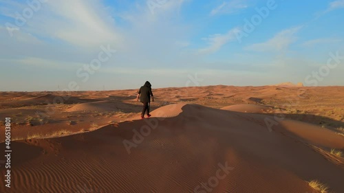 Drone View: A man walks alone in the Arabian Desert of the United Arab Emirates, landscape video of the gulf desert, UAE desert. 4K Footage photo