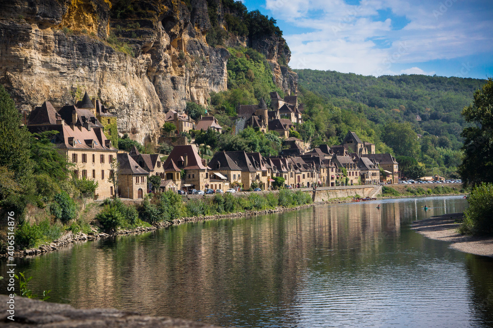 Historic building hug the river in Beynac, France