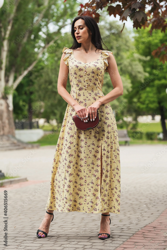 Young elegant girl posing at city street. Pretty beautiful business woman in elegant dress against city background. Young elegant girl posing at city street. Pretty beautiful business woman in elegant dress against city background.