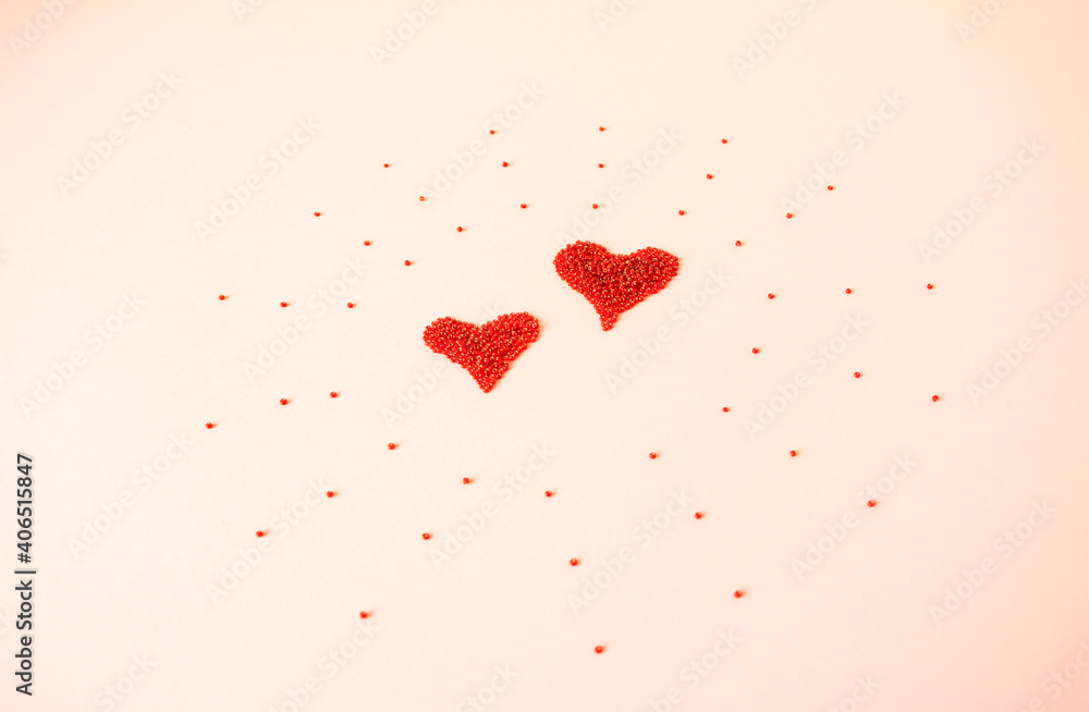 Composition of the heart as a symbol of love laid out from red beads on pink background for valentine's day.