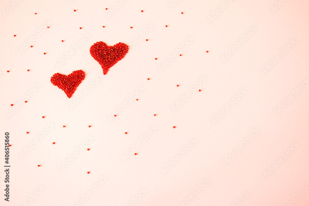 Composition of the heart as a symbol of love laid out from red beads on pink background for valentine's day.