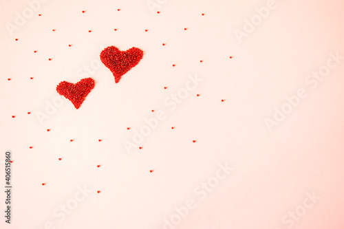 Composition of the heart as a symbol of love laid out from red beads on pink background for valentine s day.