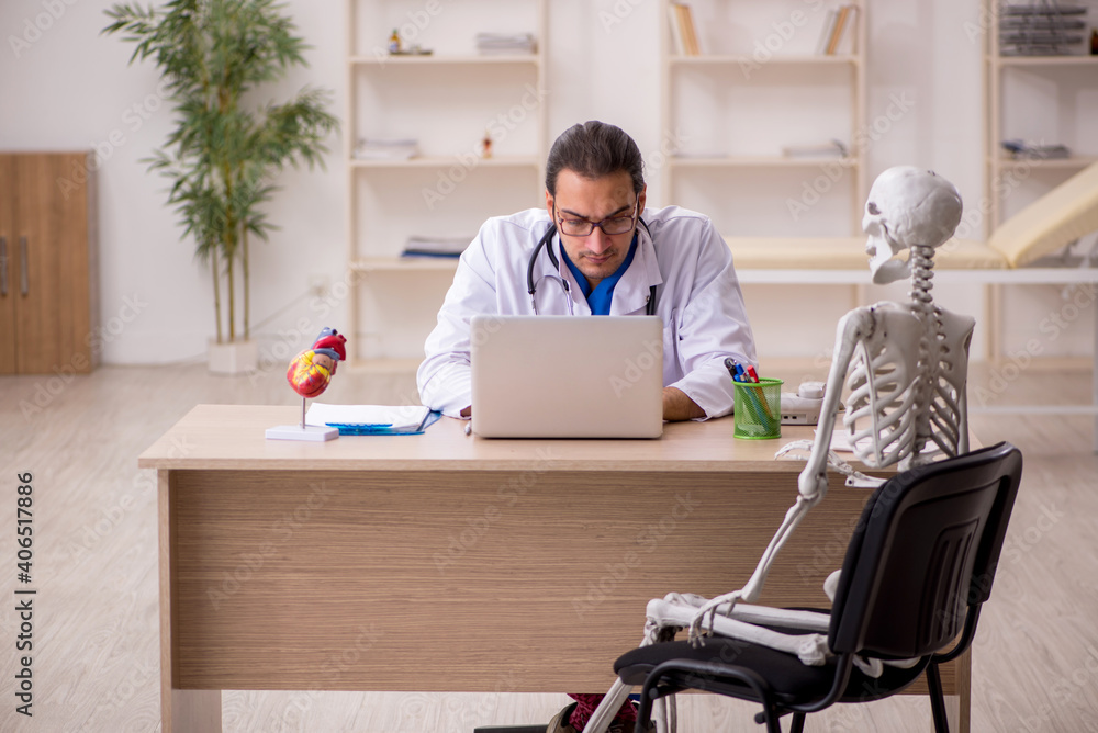 Young male doctor and skeleton patient in the clinic Young male doctor and skeleton patient in the clinic