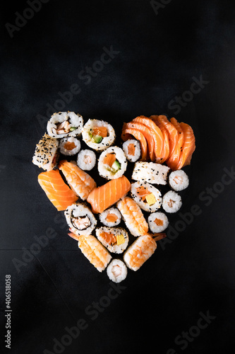 Sushi rolls unagi nigiri uramaki serving in the form of heart on a dark background. valentine\'s day romantic dinner. banner food delivery sushi rolls japanese cuisine