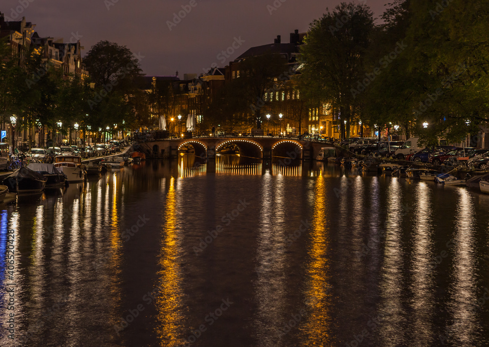 Nighttime and illuminated arched bridge in Amsterdam， Netherland