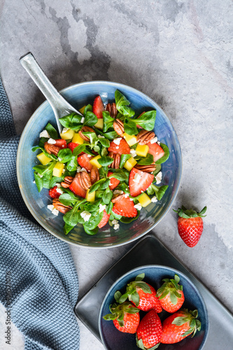 Healthy lettuce salad with mango, strawberry, pecan nuts and Feta cheese