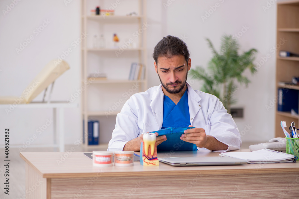 Young male odontologist working in the clinic Young male odontologist working in the clinic