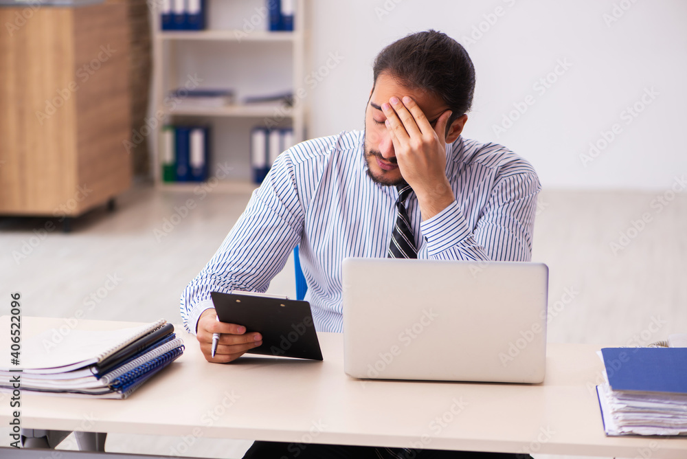 Young male employee working in the office Young male employee working in the office