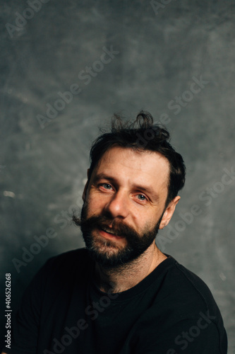 Portrait of a courageous guy with a beard and mustache on a canvas background © alexbutko_com