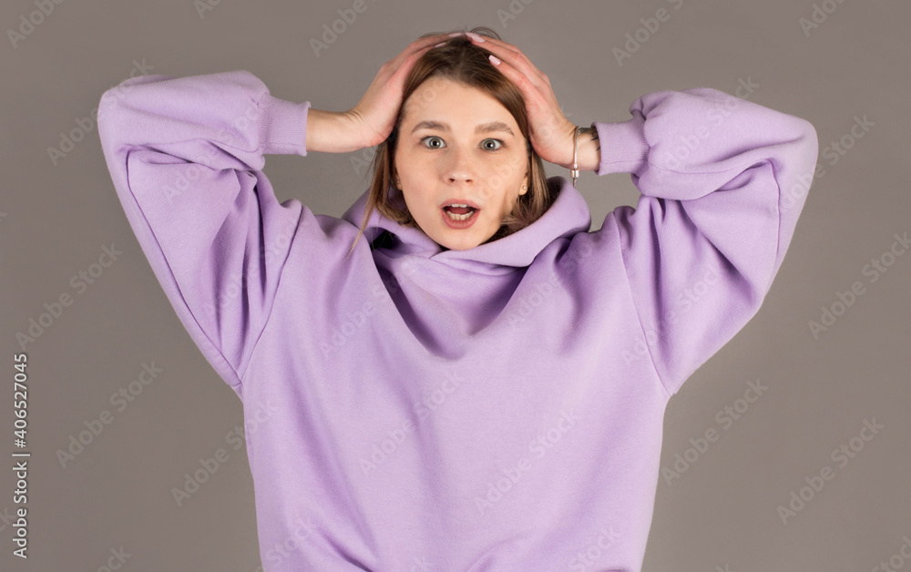 Surprised happy beautiful woman looking sideways in excitement. Isolated on gray background Surprised happy beautiful woman looking sideways in excitement. Isolated on gray background